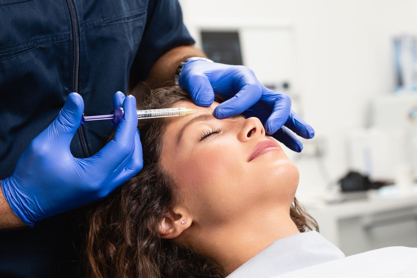 Dermatologist injecting Botox into woman's forehead for a non-surgical lift